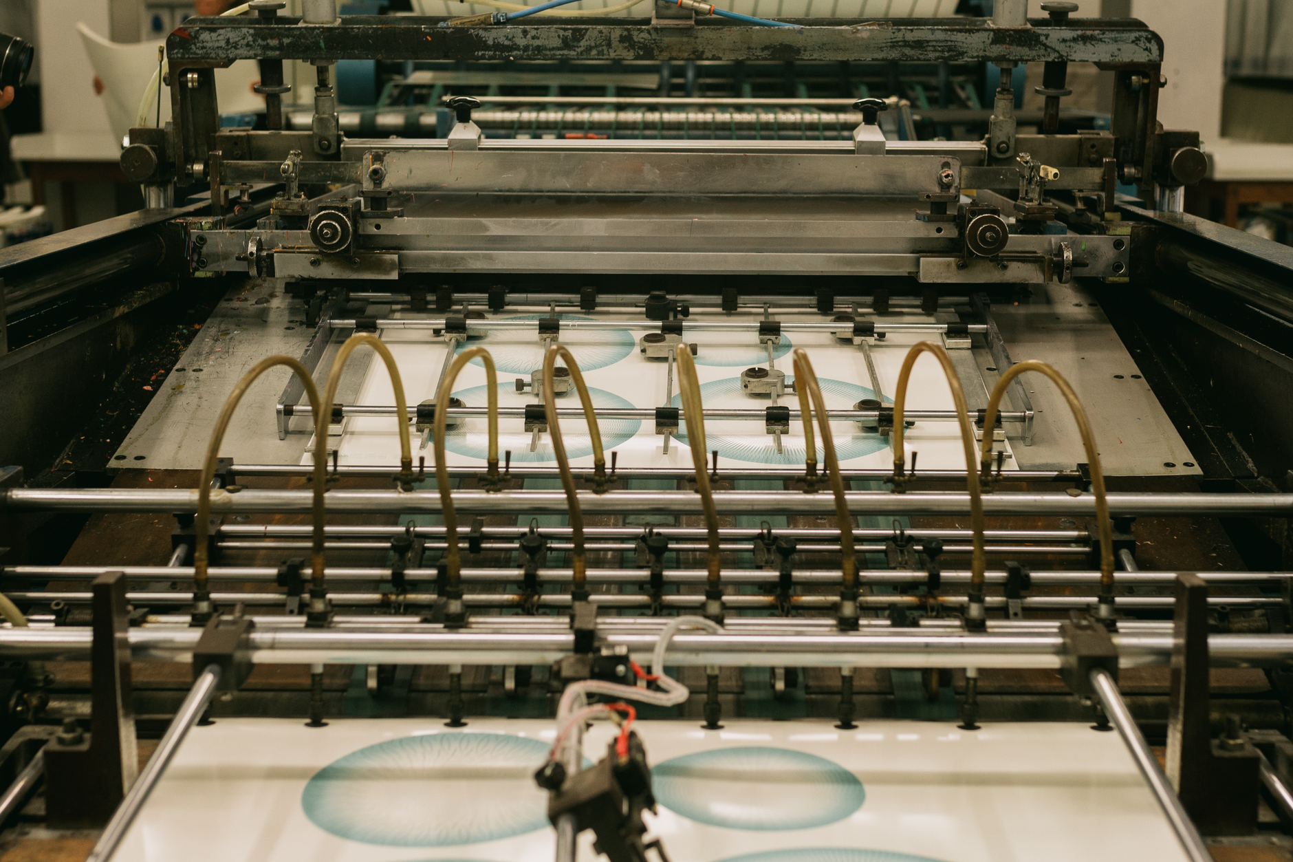 Worker cutting industrial rubber sheet on a cutting table in an Anaheim rubber shop