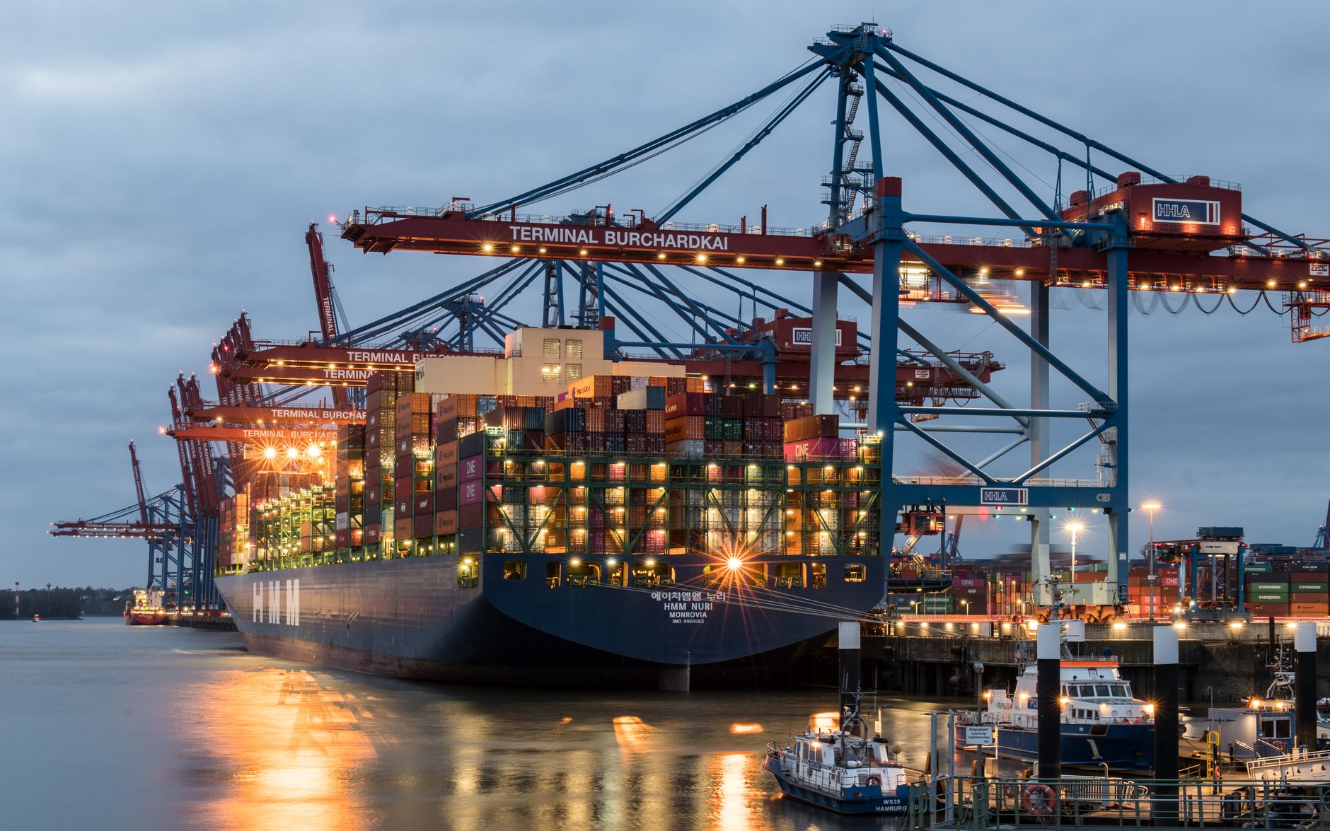 Stacked cargo shipping containers at a port, representing rubber import tariffs affecting sourcing