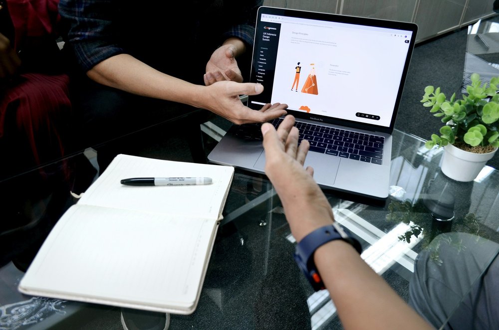 Two people reviewing a design on a laptop screen