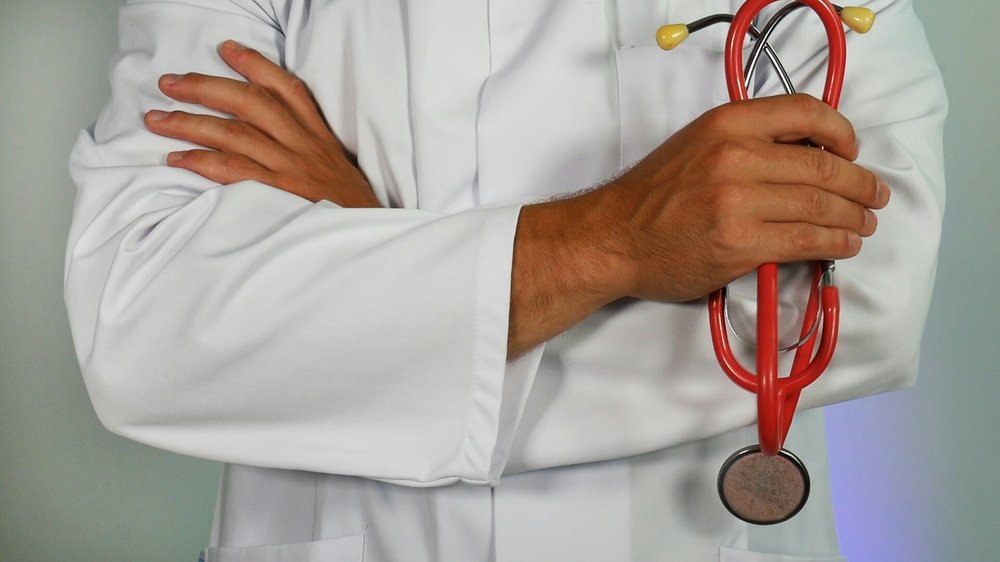 Healthcare professional in a white lab coat holding a stethoscope