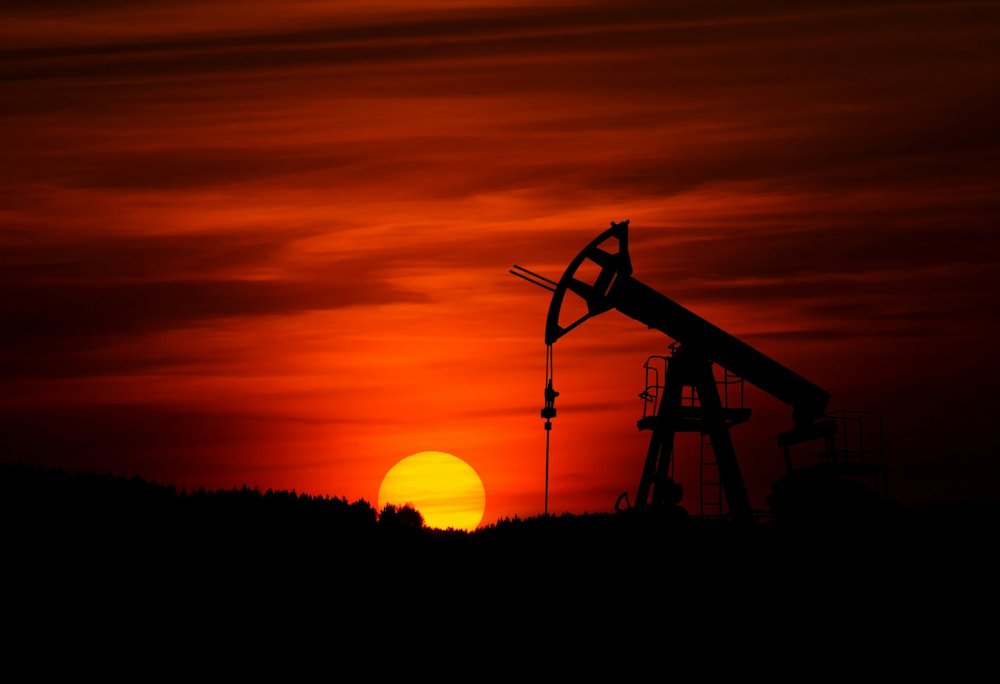 Oil pumpjack silhouetted against a sunset sky